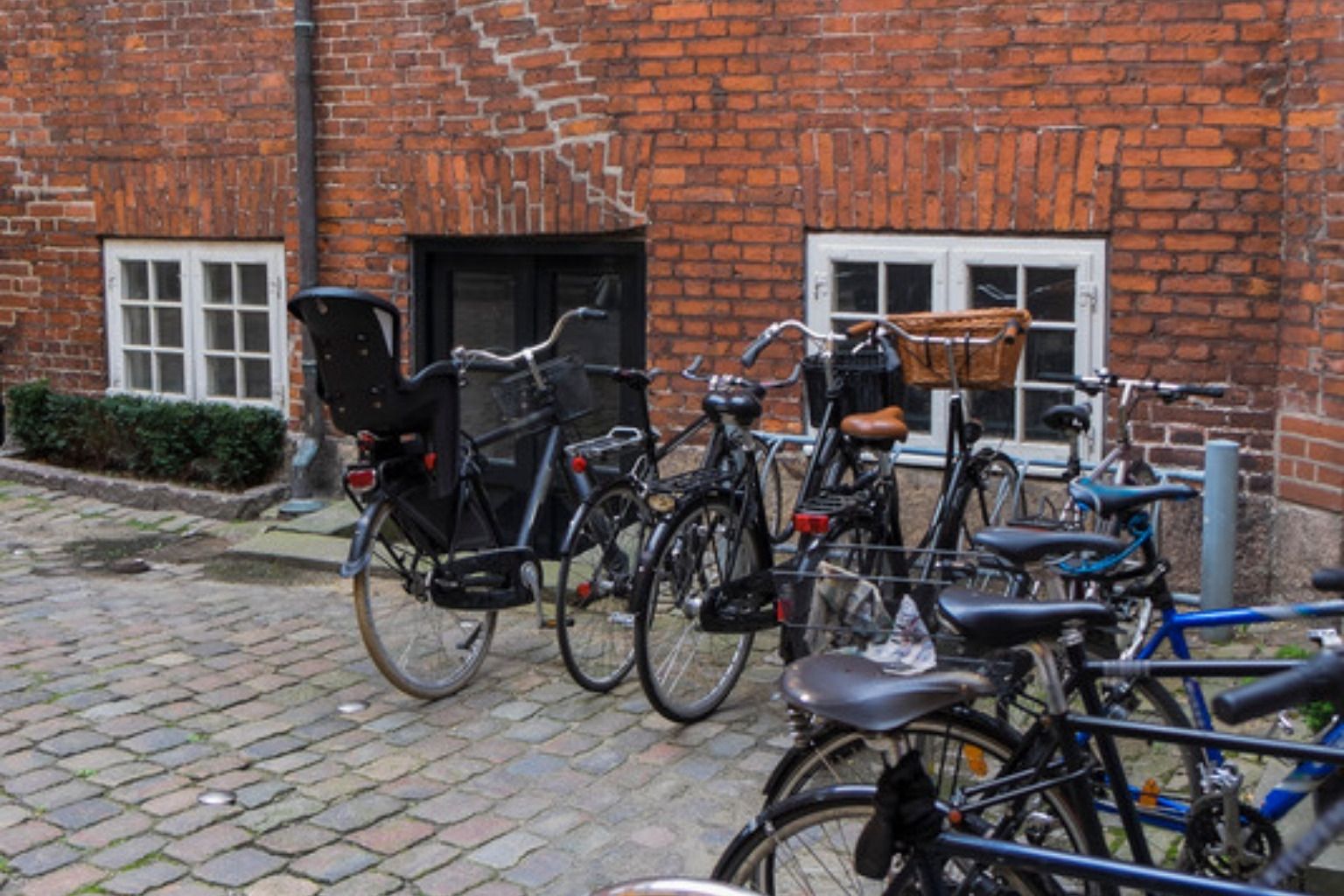 Cykler parkeret i gården ved en etageejendom